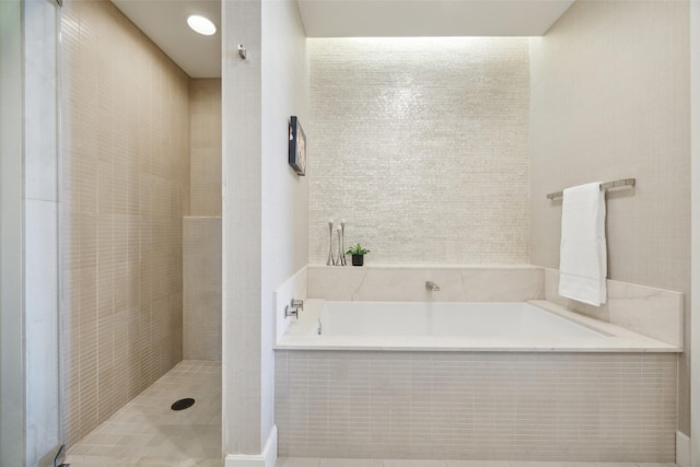 2408 Victory Park Ln Unit 1031, Dallas, TX 75219 - bathroom featuring a garden tub and tiled shower
