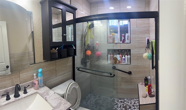 full bath with toilet, a stall shower, and a sink
