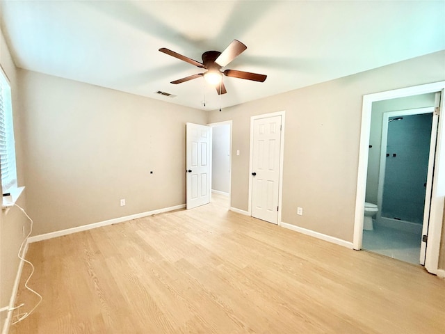 1901 SE 12th St, Mineral Wells, TX 76067 - unfurnished bedroom with light wood finished floors, baseboards, ensuite bathroom, a ceiling fan, and multiple windows