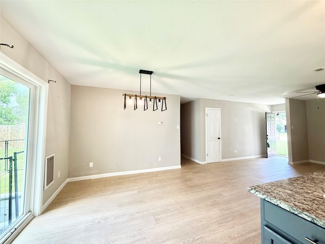 1901 SE 12th St, Mineral Wells, TX 76067 - unfurnished dining area with light wood-style floors, baseboards, and ceiling fan