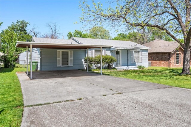 ranch-style home featuring a carport, a front lawn, fence, and driveway