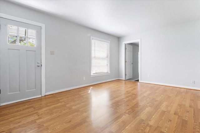 foyer entrance with light wood-style flooring and baseboards