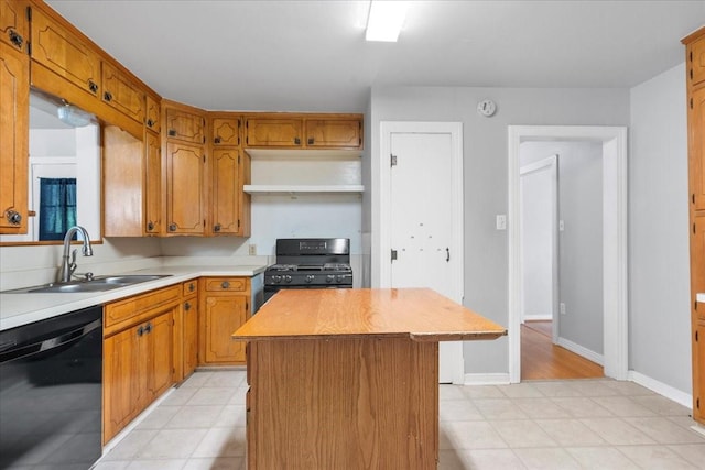kitchen with black appliances, a center island, light countertops, a sink, and brown cabinets
