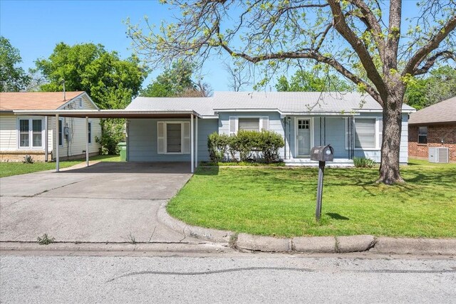 single story home featuring driveway, a front yard, and an attached carport
