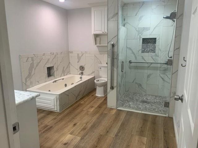 full bath with a garden tub, recessed lighting, toilet, wood finished floors, and a marble finish shower