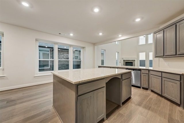 6926 Prairieside Trl, Prairie Ridge, TX 76084 - kitchen featuring dishwasher, light wood-style flooring, a fireplace, a kitchen island, and recessed lighting