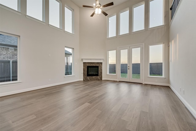6926 Prairieside Trl, Prairie Ridge, TX 76084 - unfurnished living room with a high ceiling, a ceiling fan, wood finished floors, baseboards, and healthy amount of natural light