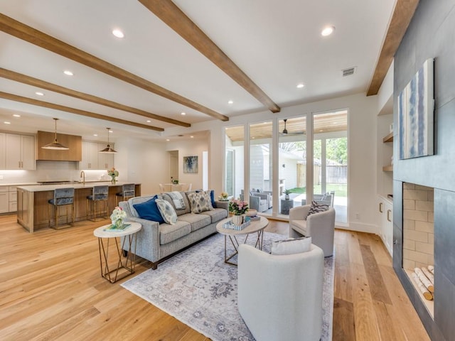 6909 Middle Cove Dr, Dallas, TX 75248 - living area with ceiling fan, a fireplace, beam ceiling, recessed lighting, and light wood-style flooring