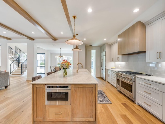 6909 Middle Cove Dr, Dallas, TX 75248 - kitchen featuring tasteful backsplash, a sink, premium range hood, high end appliances, and light wood finished floors