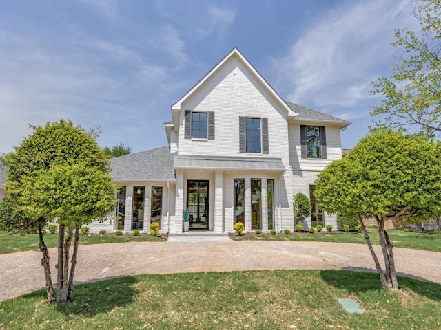 6909 Middle Cove Dr, Dallas, TX 75248 - view of front of home featuring brick siding, a front lawn, covered porch, and roof with shingles