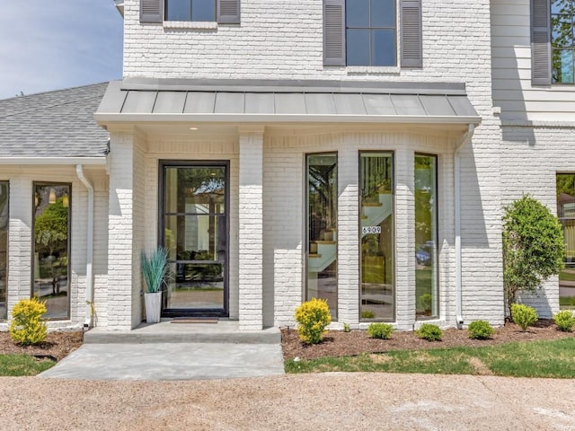 6909 Middle Cove Dr, Dallas, TX 75248 - property entrance with brick siding, metal roof, and a standing seam roof