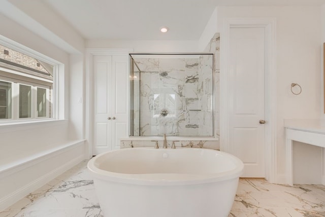 full bath featuring marble tiled flooring, a marble finish shower, a freestanding bath, and recessed lighting