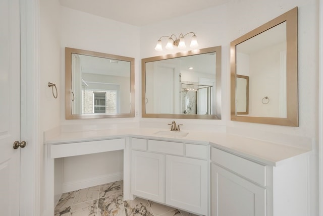 bathroom with marble look tile flooring, vanity, and a shower with door