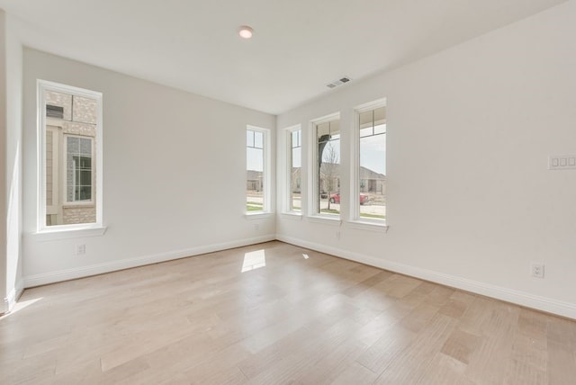spare room featuring baseboards and light wood-style flooring