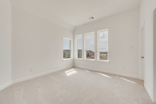 unfurnished room with light colored carpet, baseboards, and lofted ceiling