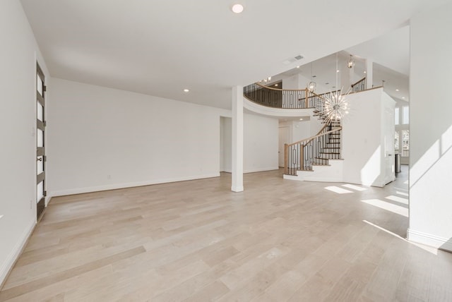 unfurnished living room featuring stairway, light wood-style floors, recessed lighting, and baseboards
