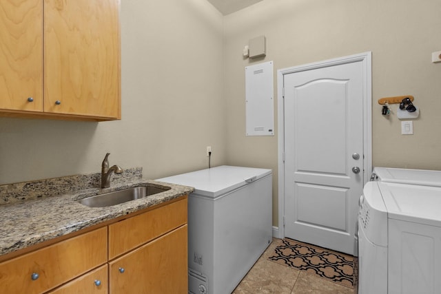 clothes washing area with washing machine and clothes dryer, cabinet space, a sink, and electric panel