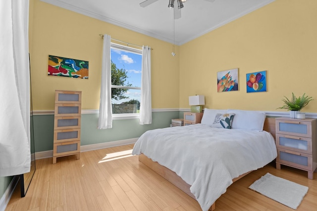 bedroom with baseboards, wood finished floors, ornamental molding, and ceiling fan