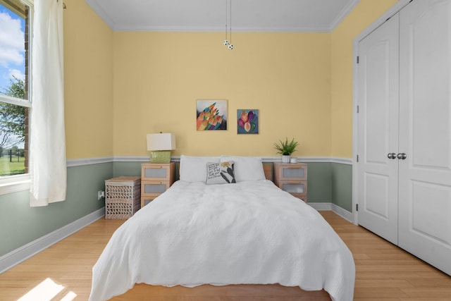 bedroom with wood finished floors, crown molding, and baseboards