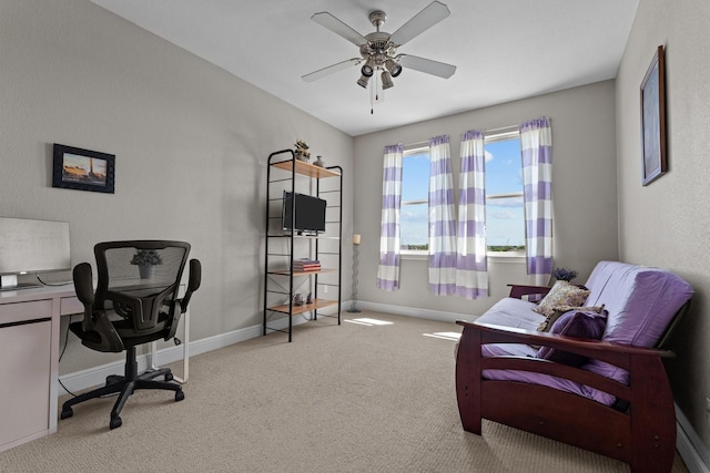 carpeted home office featuring a ceiling fan and baseboards