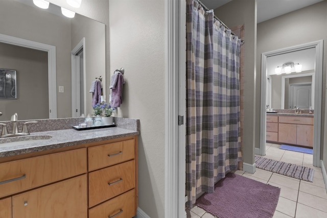 bathroom featuring tile patterned floors, vanity, and curtained shower