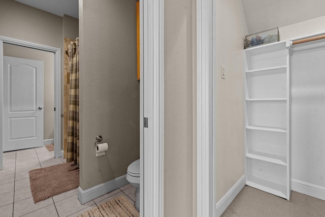 full bathroom featuring toilet, tile patterned floors, and baseboards