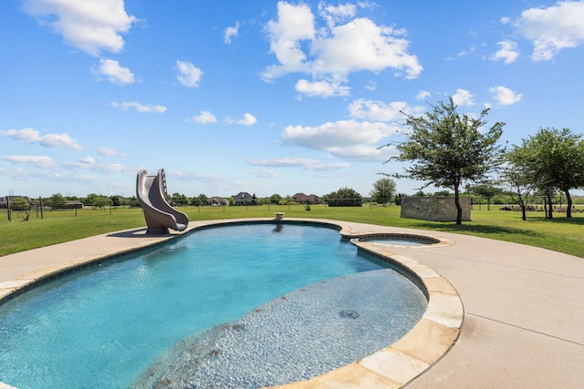 view of pool featuring a lawn, a water slide, and a pool with connected hot tub