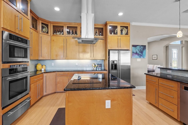 kitchen featuring a center island, tasteful backsplash, a warming drawer, stainless steel appliances, and light wood-style flooring