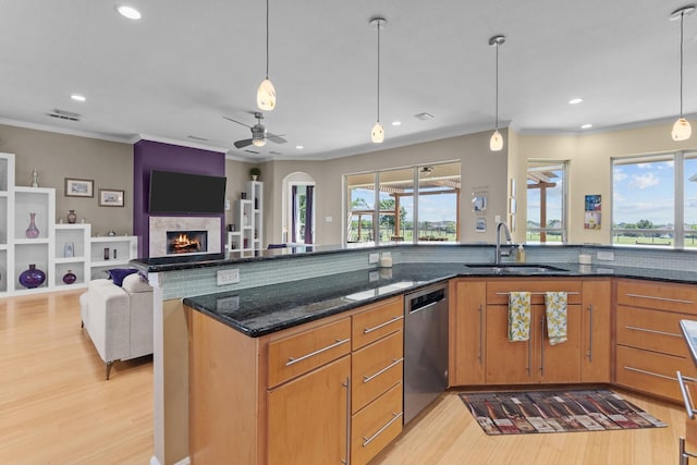kitchen with dishwasher, visible vents, a sink, light wood-style floors, and crown molding