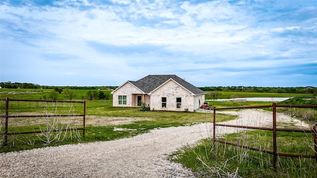 view of front of property with fence, brick siding, and a water view