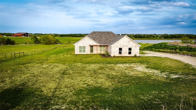 view of property exterior featuring fence, a yard, and a water view