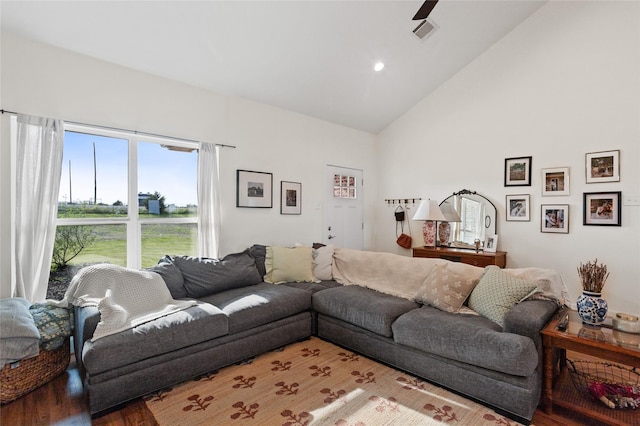 living area with wood finished floors, visible vents, and high vaulted ceiling