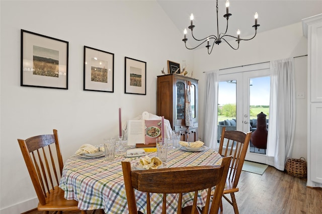 dining space with french doors, light wood-style flooring, baseboards, an inviting chandelier, and high vaulted ceiling