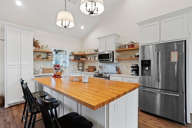 kitchen with open shelves, wood counters, appliances with stainless steel finishes, and decorative backsplash