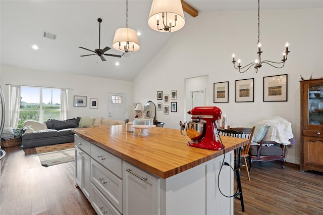 kitchen with high vaulted ceiling, visible vents, butcher block countertops, open floor plan, and white cabinetry