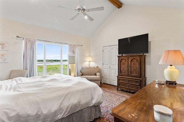 bedroom featuring high vaulted ceiling, wood finished floors, a closet, ceiling fan, and beamed ceiling