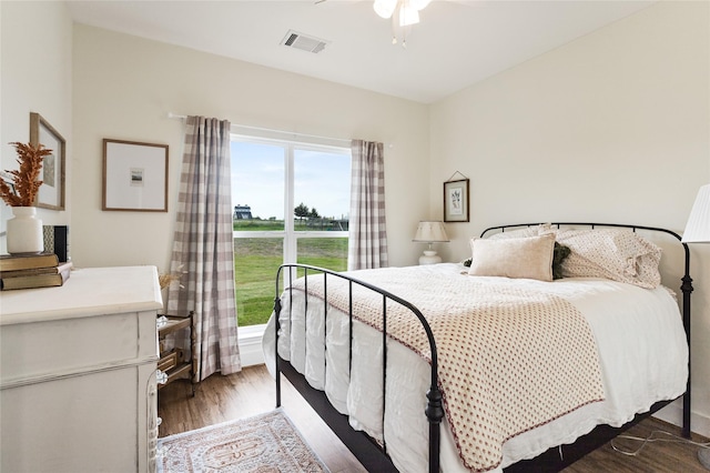 bedroom featuring wood finished floors, visible vents, and ceiling fan