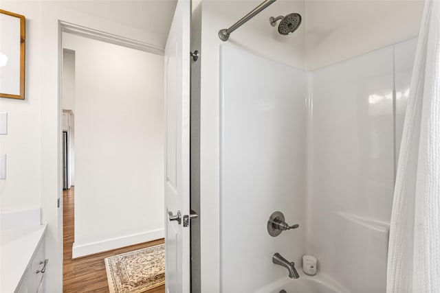 bathroom with baseboards, vanity, wood finished floors, and shower / bathtub combination with curtain