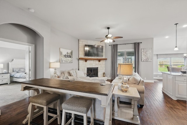 1057 Canterbury Ln, Forney, TX 75126 - living area featuring a ceiling fan, a fireplace, plenty of natural light, and dark wood-style floors