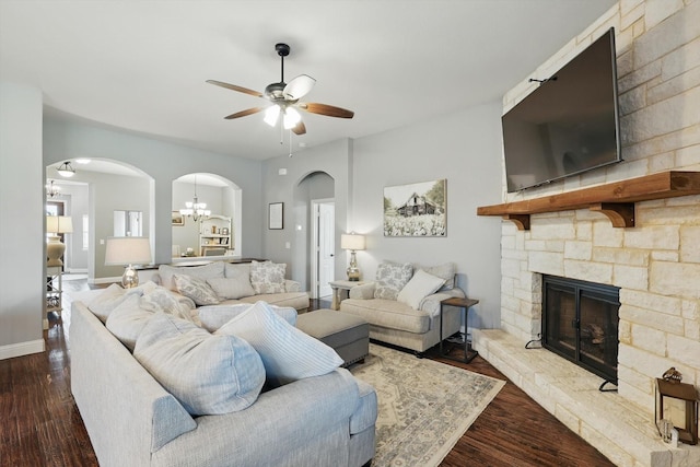 1057 Canterbury Ln, Forney, TX 75126 - living area with arched walkways, ceiling fan, a stone fireplace, and wood finished floors