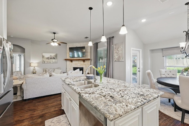 1057 Canterbury Ln, Forney, TX 75126 - kitchen featuring a sink, appliances with stainless steel finishes, ceiling fan, dark wood-style flooring, and a stone fireplace