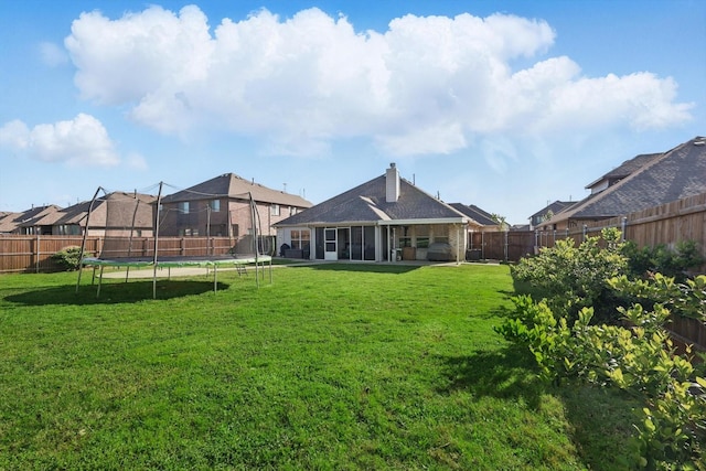 1057 Canterbury Ln, Forney, TX 75126 - rear view of house with a trampoline, a sunroom, a chimney, and a patio