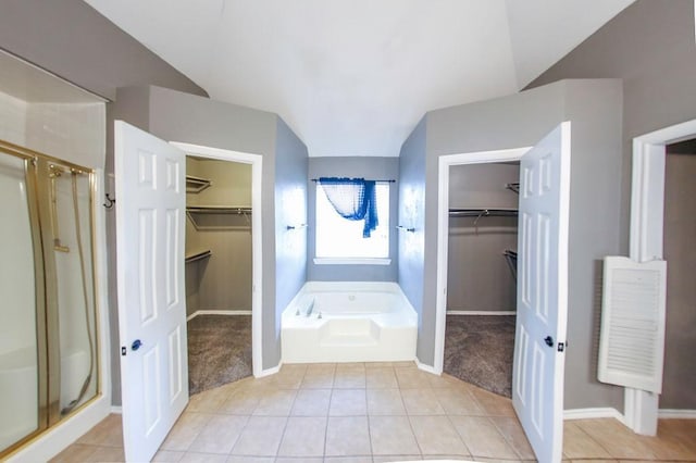 bathroom with a shower stall, baseboards, and a garden tub
