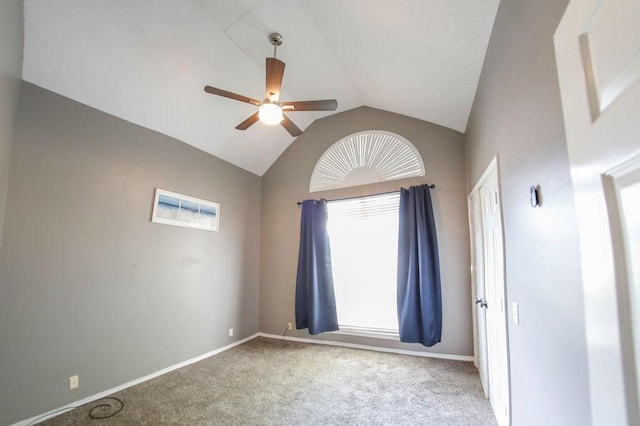 carpeted spare room with ceiling fan, baseboards, and lofted ceiling