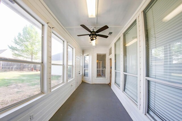 unfurnished sunroom featuring a ceiling fan and visible vents