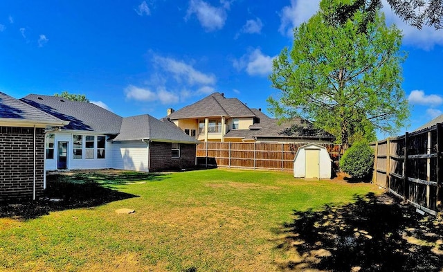 view of yard featuring a fenced backyard, an outdoor structure, and a storage unit