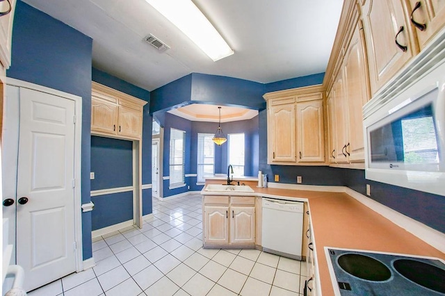 kitchen featuring light brown cabinets, white appliances, light tile patterned flooring, visible vents, and a sink