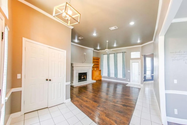 unfurnished living room featuring ornamental molding, tile patterned floors, and a fireplace