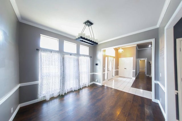 interior space featuring crown molding, wood finished floors, and baseboards