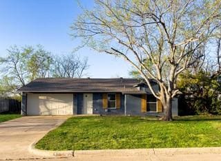 ranch-style home featuring a garage, driveway, and a front lawn